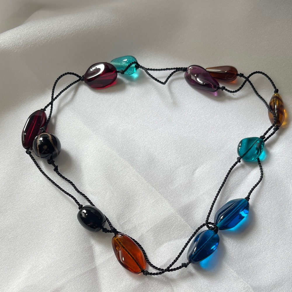 Glass beads necklace on a black cord.